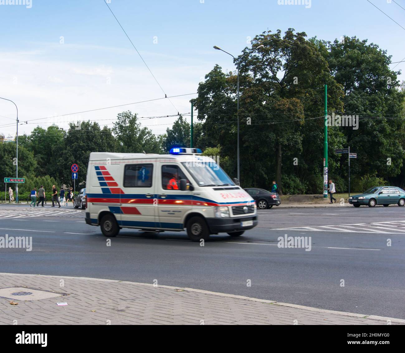 POZNAN, POLONIA - 28 ago 2013: Ambulanza con luci che guidano un incrocio nel centro di Poznan, Polonia Foto Stock