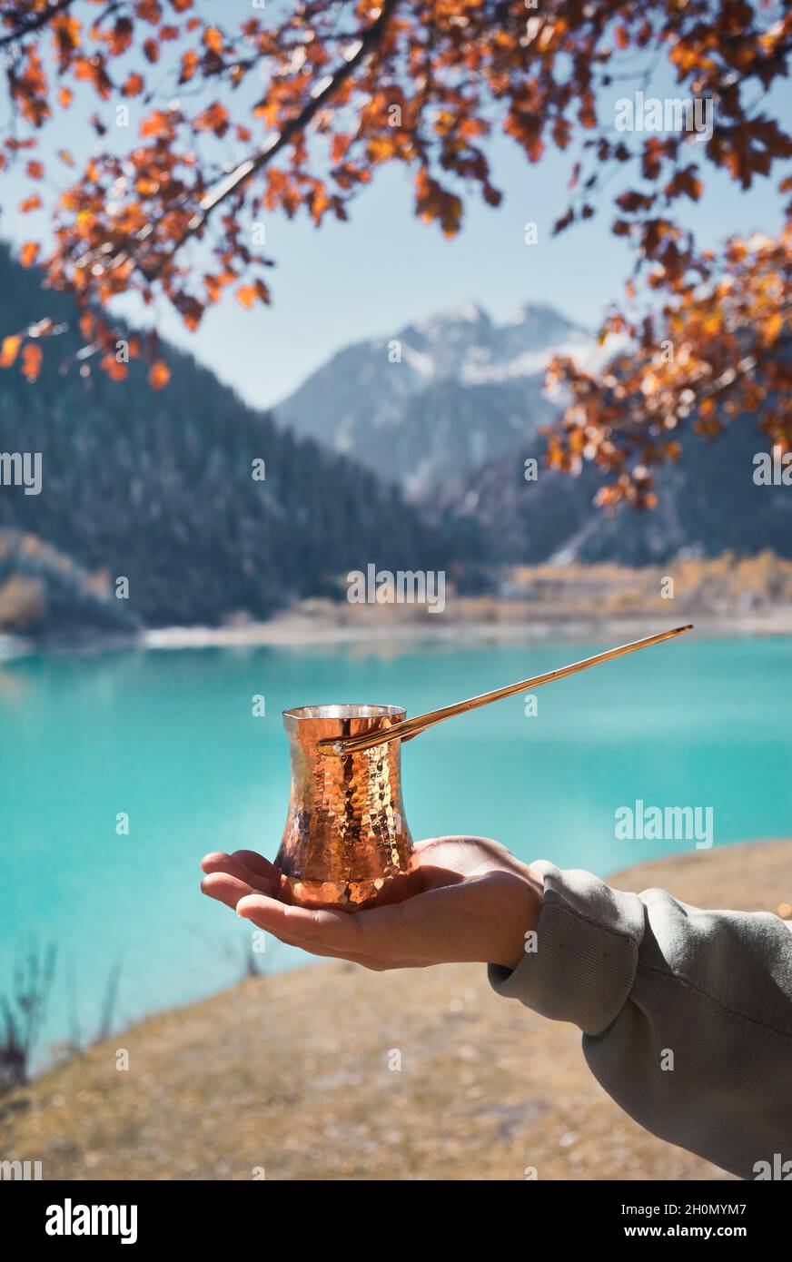 Cezve rame per caffè in autunno lago campeggio in montagna. Preparazione del caffè all'aperto Foto Stock