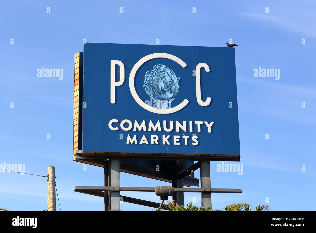 I mercati comunitari PCC si insignono su un cartellone contro un cielo nel tardo pomeriggio a Seattle, Washington. Foto Stock