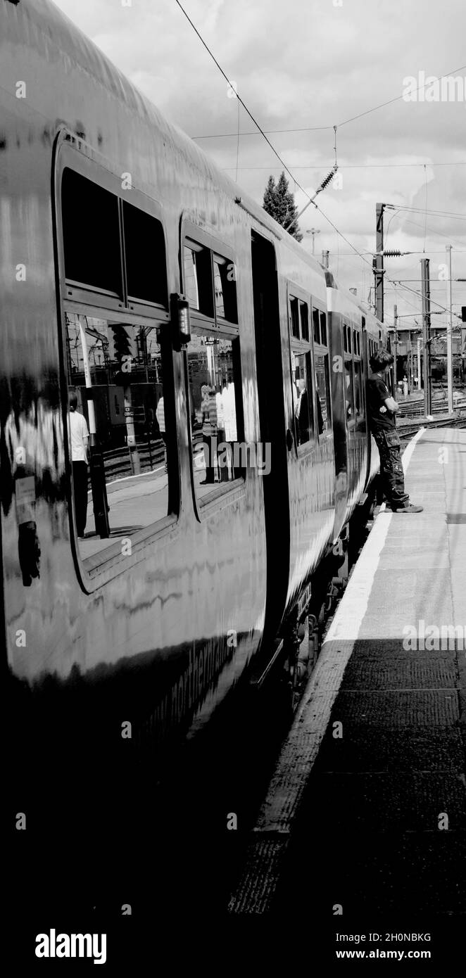 Immagine verticale, in attesa di un treno, immagine in bianco e nero Foto Stock