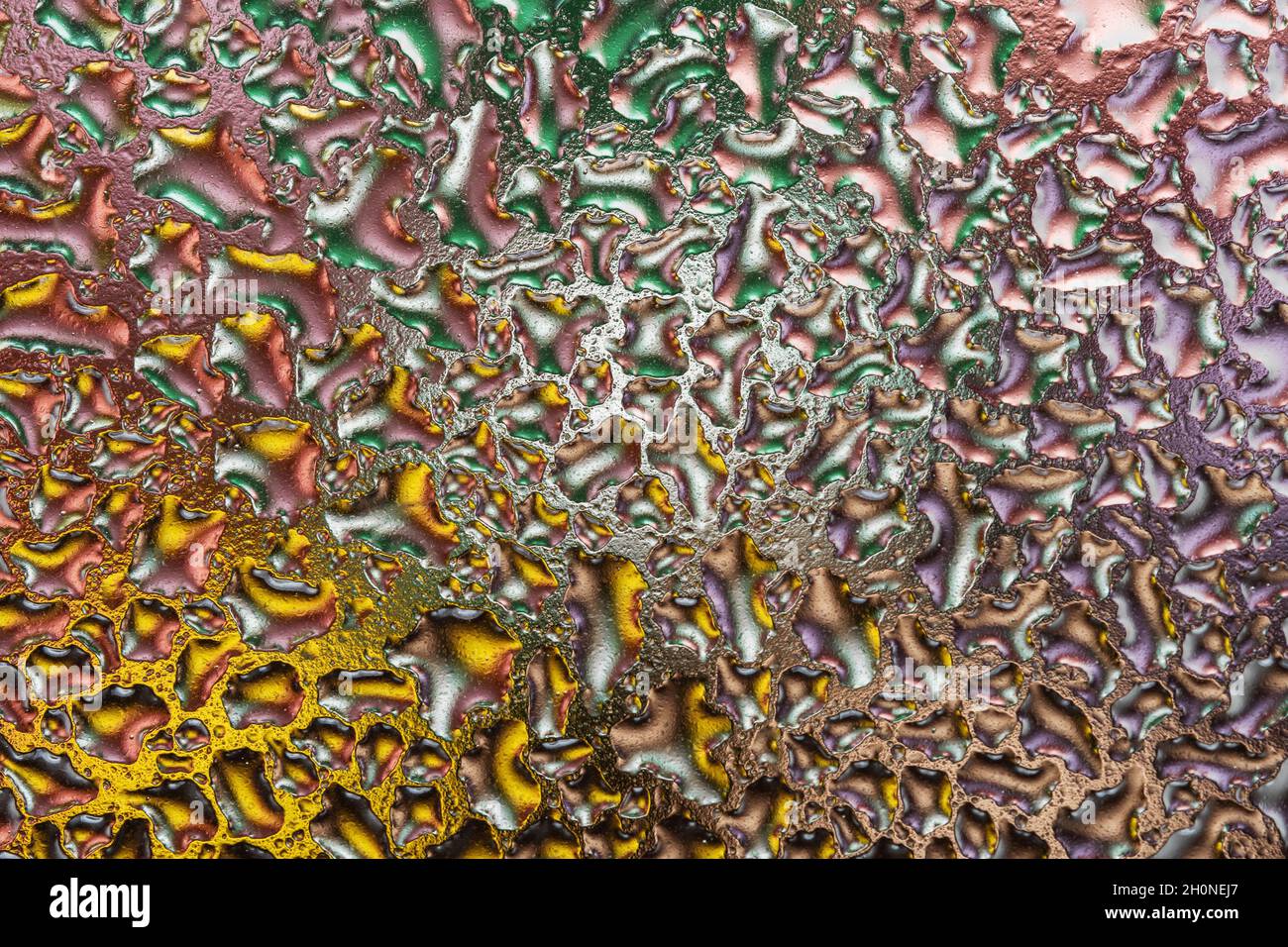 Macroscopio di gocce d'acqua colorate su vetro. Sfondo astratto. Foto Stock