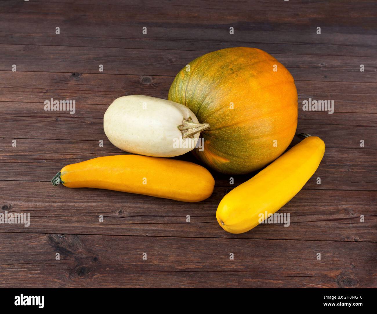 Zucche e zucchine su sfondo di legno scuro. Autunno squash. Stagione di ringraziamento ancora vita. Foto Stock
