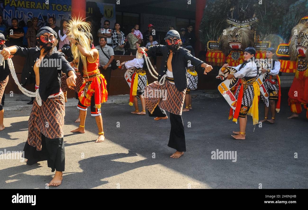 Reog Ponorogo Dance, una danza composta da diversi ballerini, tra cui ballerini con maschere delle tigri e piume di pavone e un gruppo di musicisti. Foto Stock