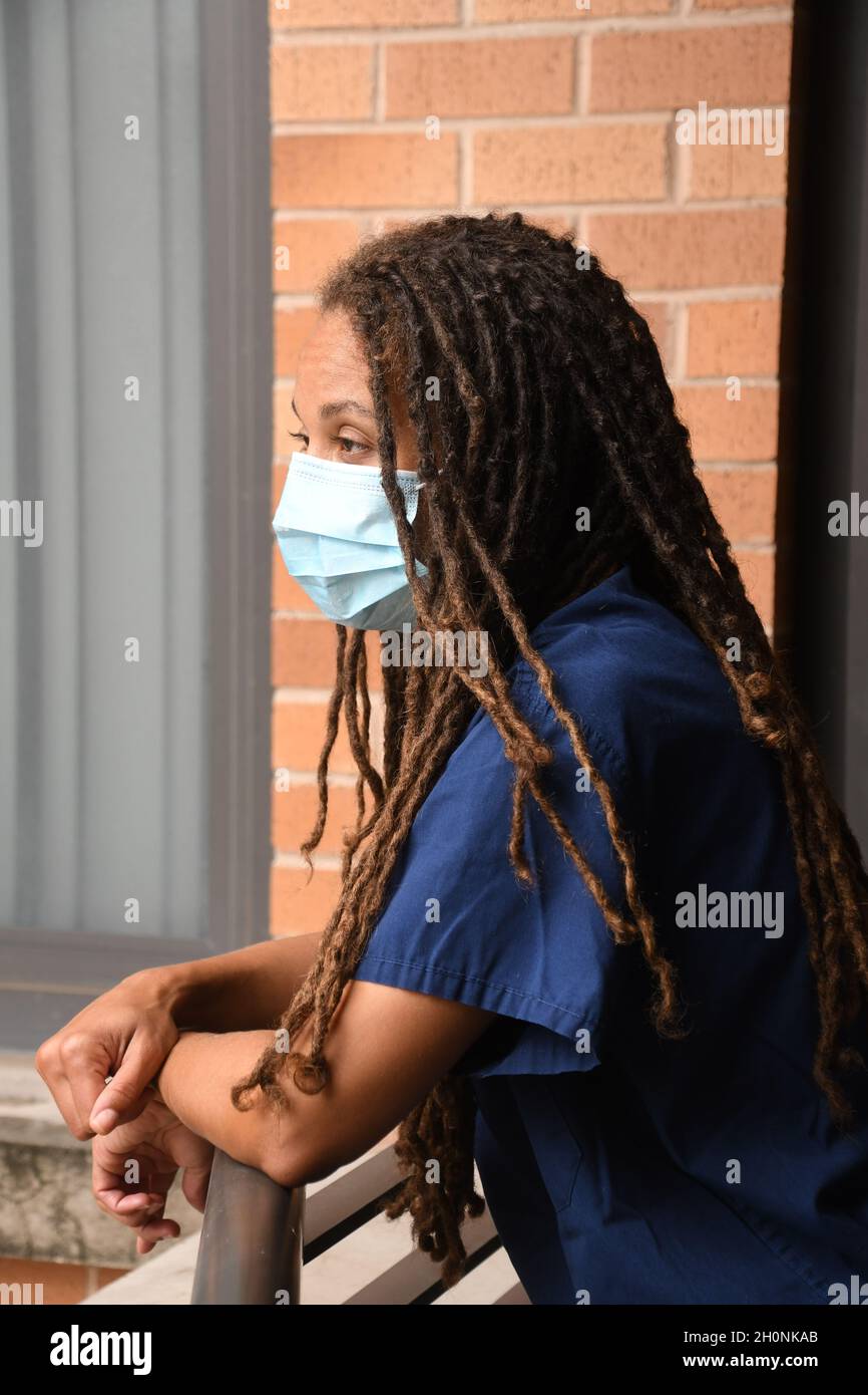 Usurato medico femminile in prima linea durante la pandemia globale di Covid-19. Foto Stock
