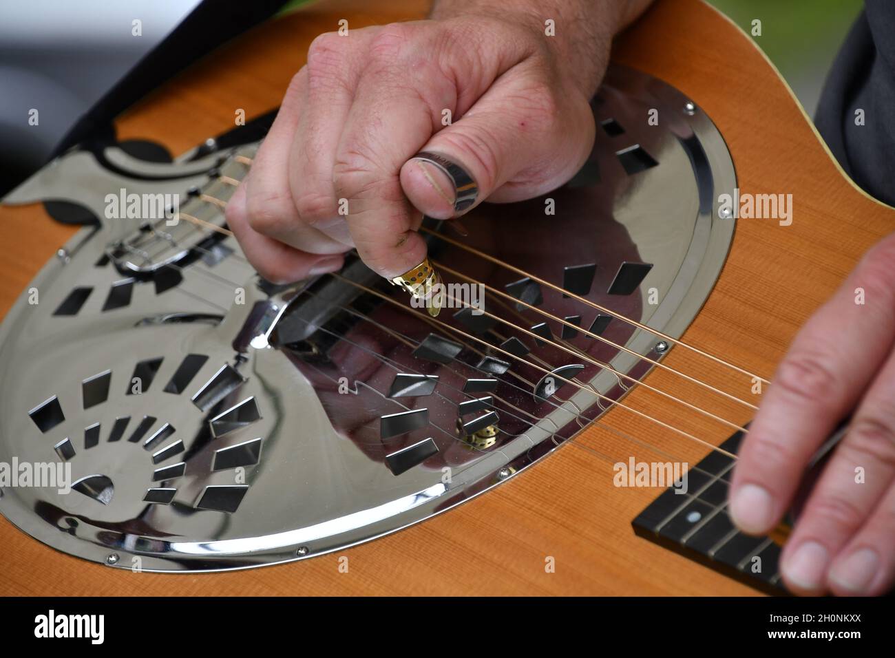 La mano maschile suona il Dobro per la musica bluegrass. Foto Stock