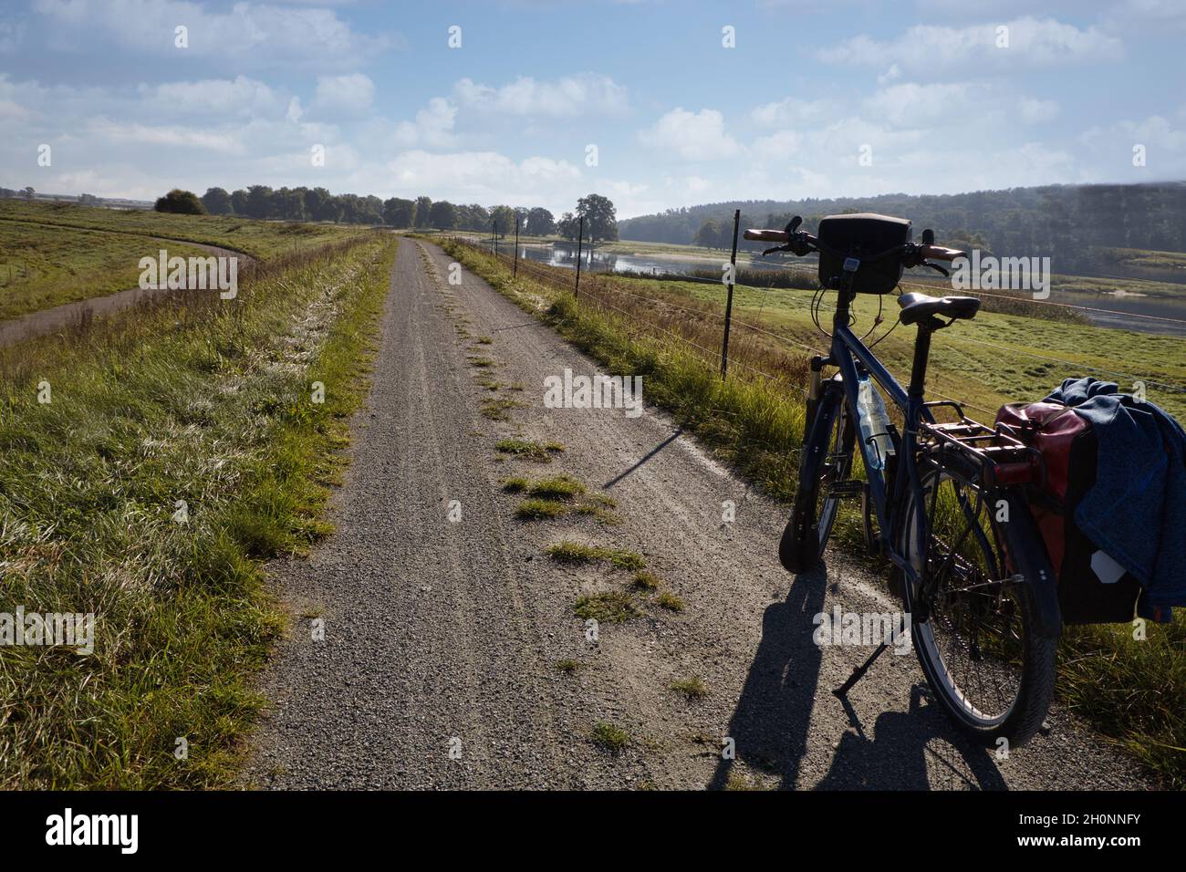 bicicletta sulla diga sulla pista ciclabile dell'elba sullo sfondo del fiume tedesco elbe, è anche il sentiero della cortina di ferro Foto Stock