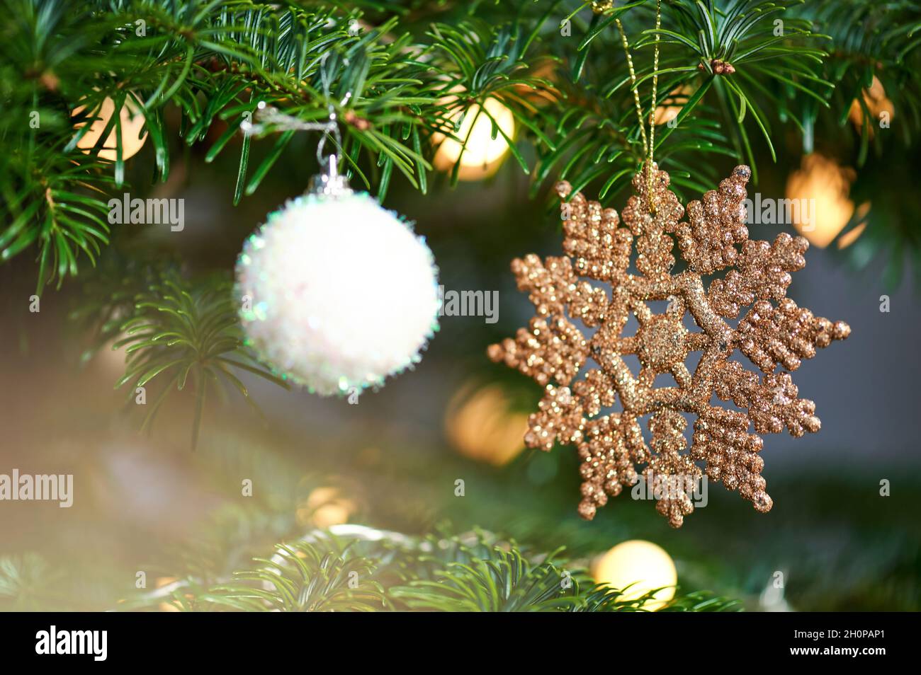 Le stelle ornamento di Natale appendono su sfondo sfocato albero Foto Stock