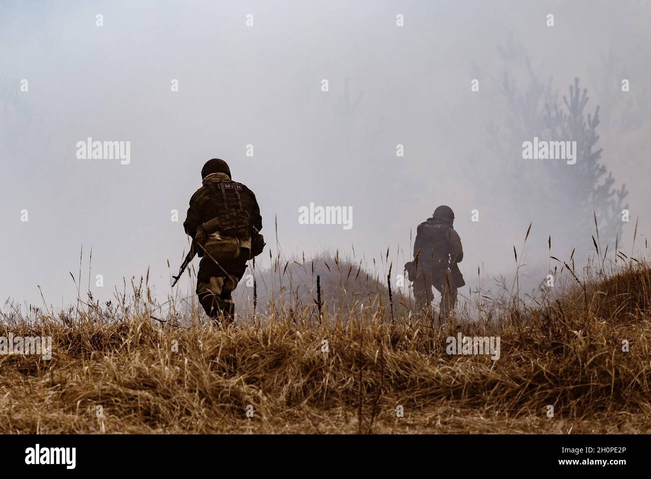 I poliziotti della sommossa entrano nel fumo da una miniera esplosa, durante la fase di campo dell'esercizio. Nella regione di Voronezh si è svolto un complesso esercizio tattico e speciale. All'incontro hanno partecipato dipendenti e militari della Guardia Nazionale e uffici regionali dei dipartimenti di potere dello Stato. Foto Stock