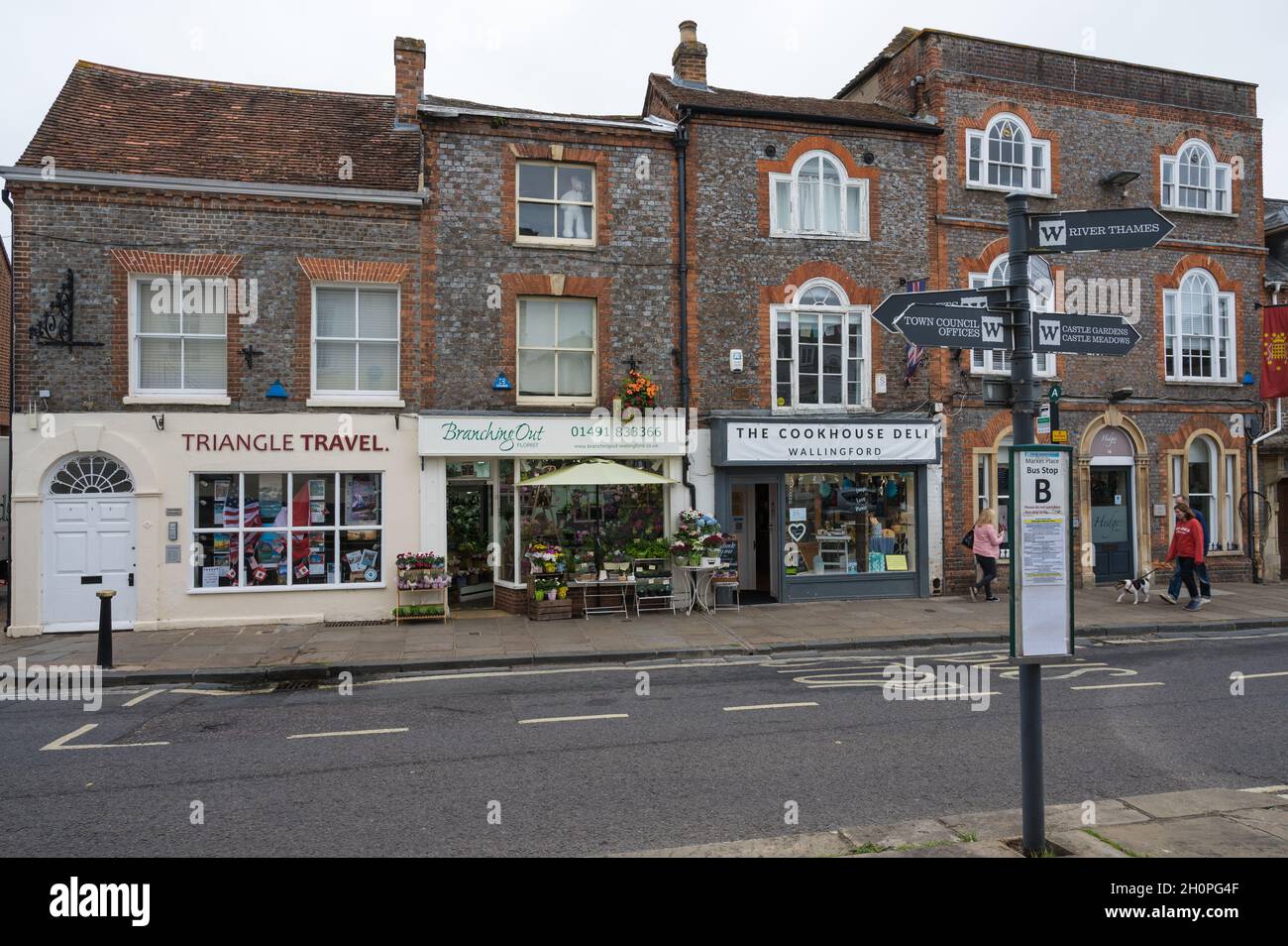 Pittoreschi negozi e fermata dell'autobus con indicazioni locali. Market Place, Wallingford, Oxfordshire, Inghilterra, Regno Unito Foto Stock