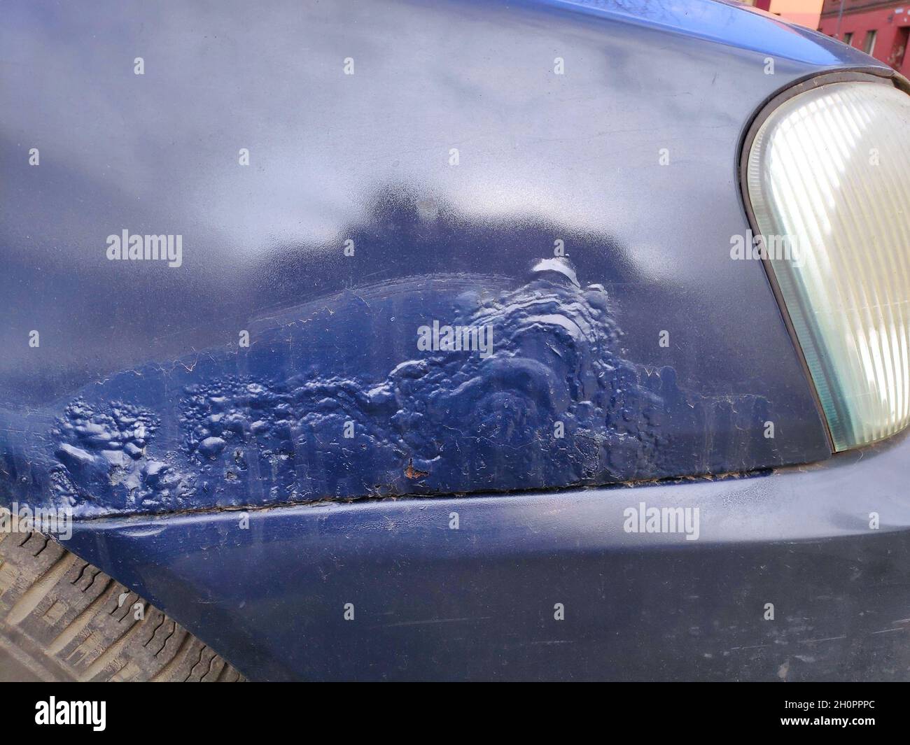 Arrugginimento del parafango anteriore in una vecchia vettura. Danni causati dalle intemperie nel veicolo. Foto Stock