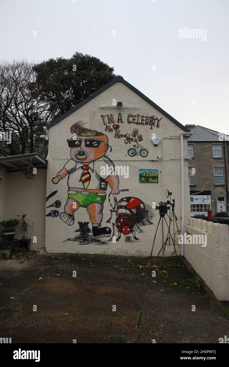 Un edificio ad Abergele, nel Galles del Nord, con un murale che raffigura il reality show i'm A Celebrity Get Me out of Here, girato nel vicino castello di Gwrych. Foto Stock