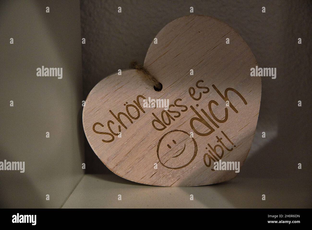 Primo piano di un cuore decorativo in legno con un testo in tedesco che dice "è bello che sei qui" Foto Stock