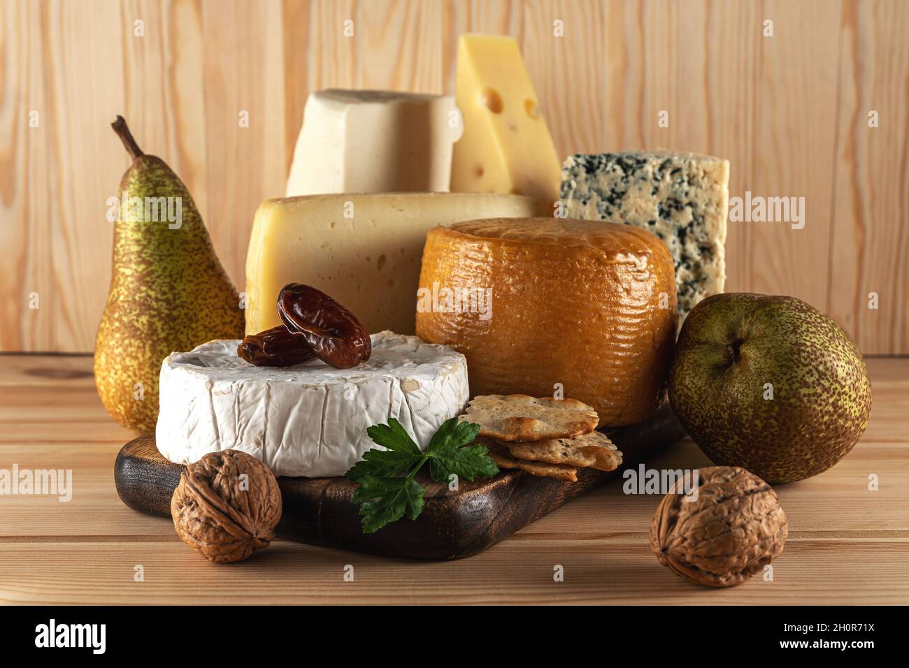 Assortimento di diversi tipi di formaggio su tavola di legno. Sfondo di formaggio. Foto Stock