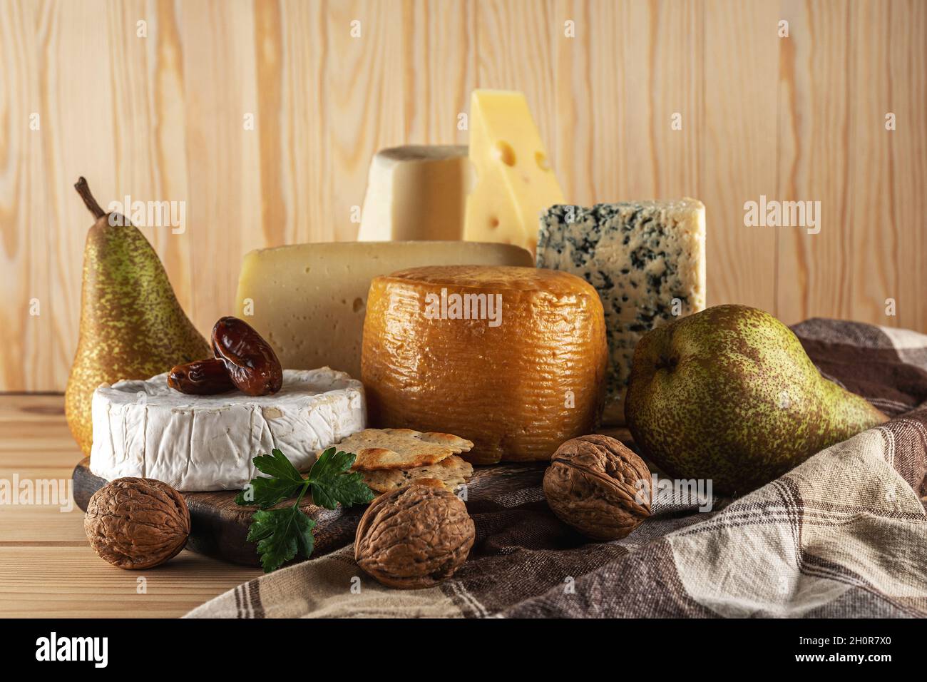 Assortimento di diversi tipi di formaggio su tavola di legno. Sfondo di formaggio. Foto Stock