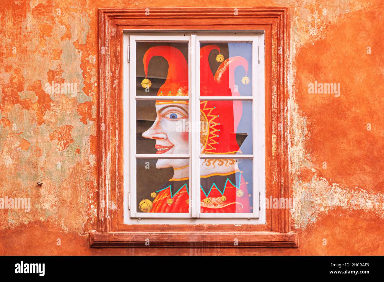 Paesaggio urbano - vista del jester a mezza faccia, poster nella finestra di un antico edificio medievale a Cesky Krumlov, Repubblica Ceca Foto Stock