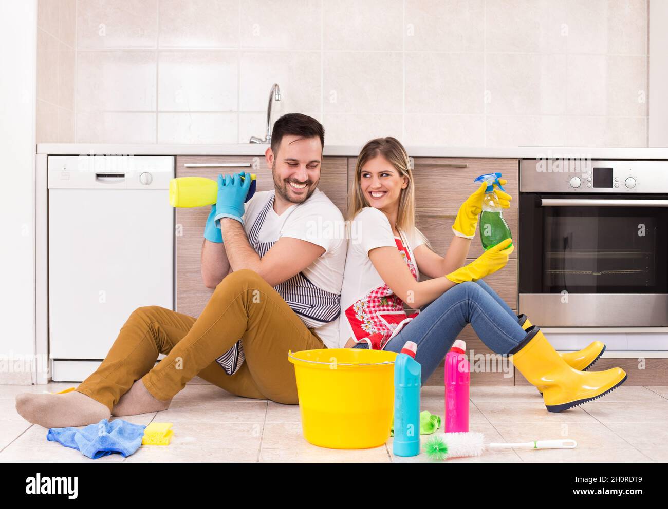 Giovane coppia che si diverte sul piano della cucina dopo aver finito le faccende Foto Stock