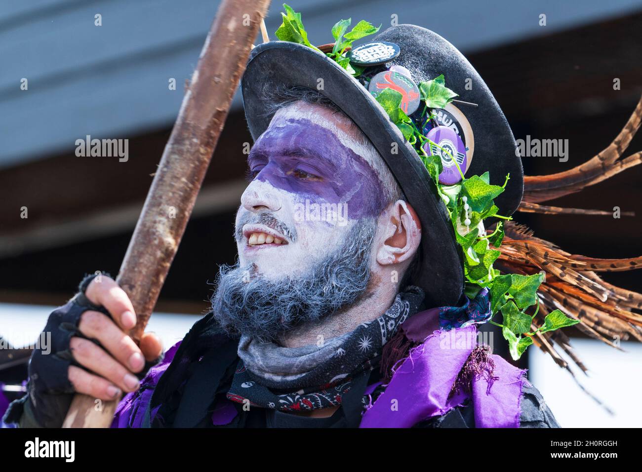 Primo piano del volto dipinto di bianco e viola di una ballerina morris dal Black Swan Border Morris mentre balla al festival della settimana del folclore di Broadstairs Foto Stock
