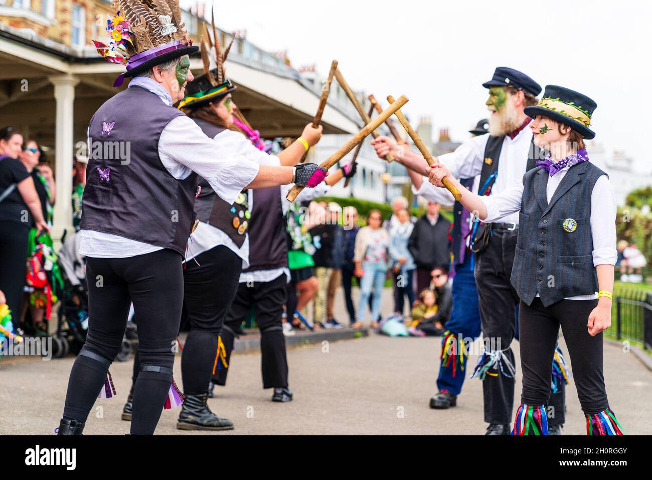 Dead Horse morris balla sul lungomare durante il festival della settimana popolare di Broadstairs. Due file di ballerini che si affacciano l'un l'altro tenendo pali di legno. Foto Stock
