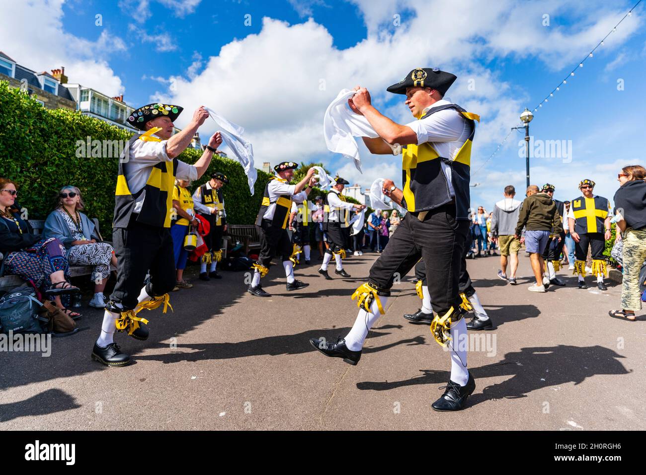 Due file di uomini Wantsum Morris ballano all'aperto tenendo in mano fazzoletti bianchi al festival della settimana popolare di Broadstairs. Sole, cielo blu. Foto Stock