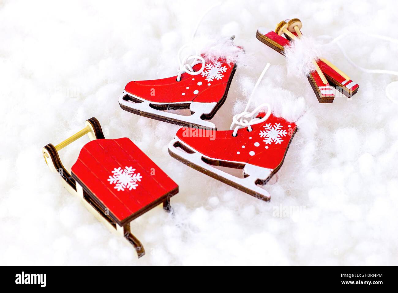 Scarpe da pattinaggio rosso brillante vintage, sci, slitta su sfondo bianco di neve artificiale. Sport invernali, Natale e Capodanno festa conce Foto Stock