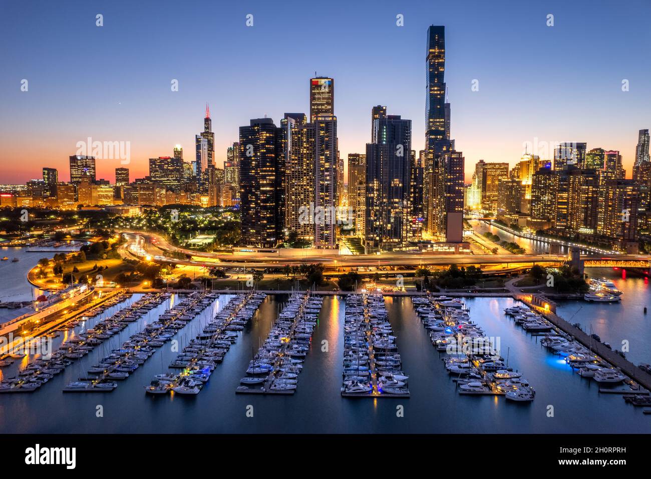 Vista aerea dello skyline della città e delle barche nel porticciolo al tramonto, Chicago, Illinois, USA Foto Stock