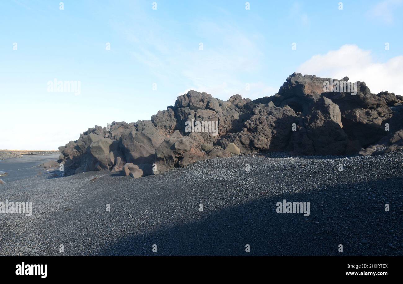 Islanda con una spiaggia di sabbia nera e formazioni di roccia lavica. Foto Stock