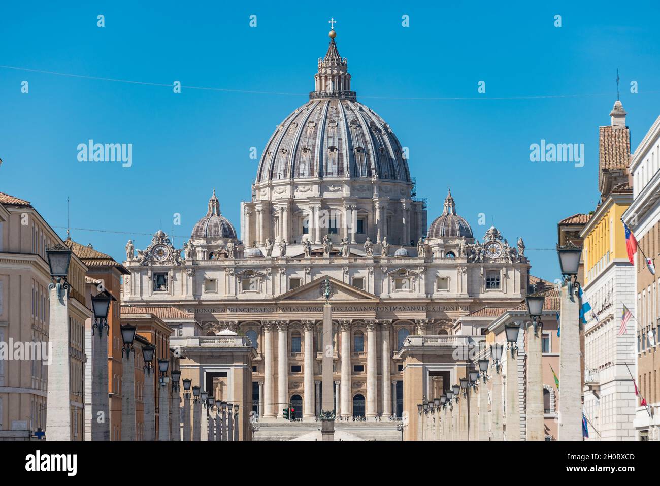 La cupola della Basilica di San Pietro e le sue statue di santi in Piazza San Pietro, vista della Città del Vaticano da Via della conciliazione a Roma, Italia, aga Foto Stock