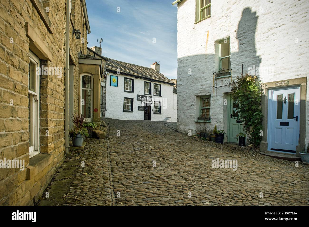 La strada principale acciottolata che attraversa il villaggio Cumbria di Dent Foto Stock
