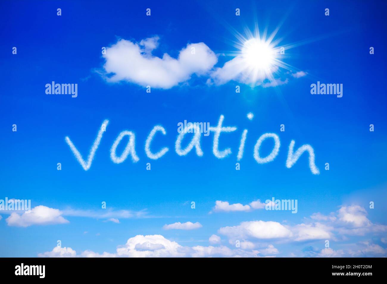 Vacanza scritta su un cielo blu soleggiato, simbolo per sognare giornate estive calde e spensierate con sole senza fine. Modello di sfondo. Foto Stock