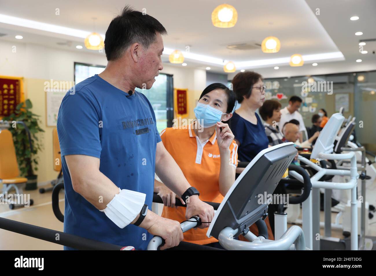Shanghai, Cina. 13 ottobre 2021. Citizen Shi Baomin sperimenta un tapis roulant riprogettato per gli anziani sotto la guida del personale di un centro di cura senior nel distretto di Xuhui di Shanghai, Cina orientale, 13 ottobre 2021. Il centro di assistenza senior, denominato 'Sport and Health Home for Elders', è un centro fitness multifunzionale per gli anziani. Fornisce agli anziani servizi 'one-stop' come il test di idoneità fisica, il test di salute di base e la guida scientifica di idoneità, ecc credito: Wang Xiang/Xinhua/Alamy Live News Foto Stock