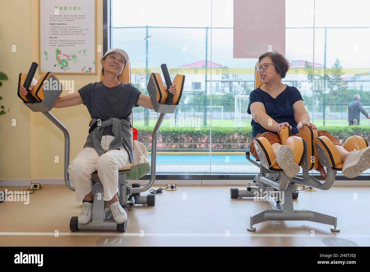 Shanghai, Cina. 13 ottobre 2021. Gli anziani chiacchierano mentre si esercitano in un centro di cura senior nel distretto di Xuhui di Shanghai, Cina orientale, 13 ottobre 2021. Il centro di assistenza senior, denominato 'Sport and Health Home for Elders', è un centro fitness multifunzionale per gli anziani. Fornisce agli anziani servizi 'one-stop' come il test di idoneità fisica, il test di salute di base e la guida scientifica di idoneità, ecc credito: Wang Xiang/Xinhua/Alamy Live News Foto Stock