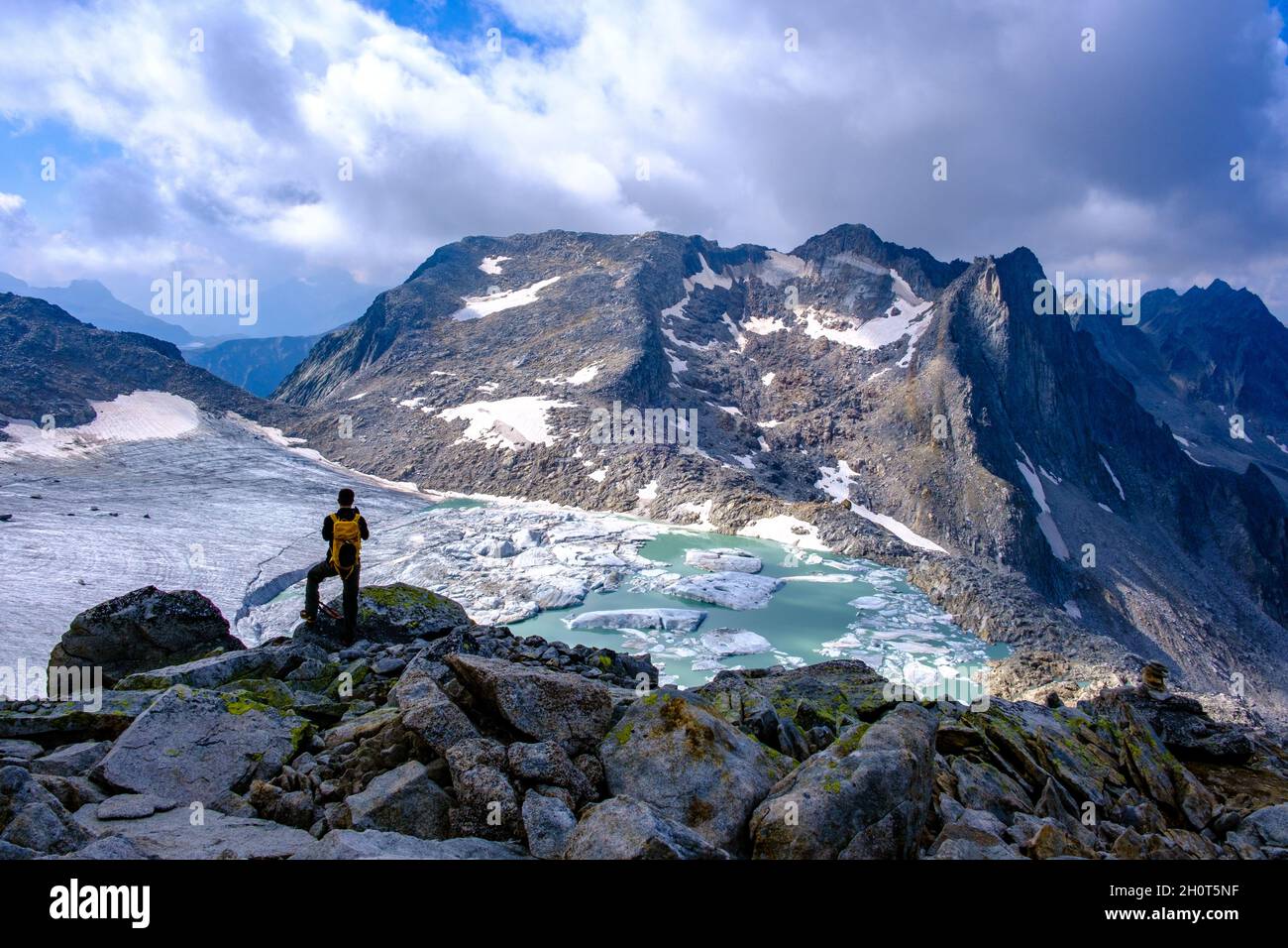 Arrampicatore ammirando il ghiacciaio Chüebodengletscher, la valle del Bedretto, il Ticino, la Svizzera Foto Stock