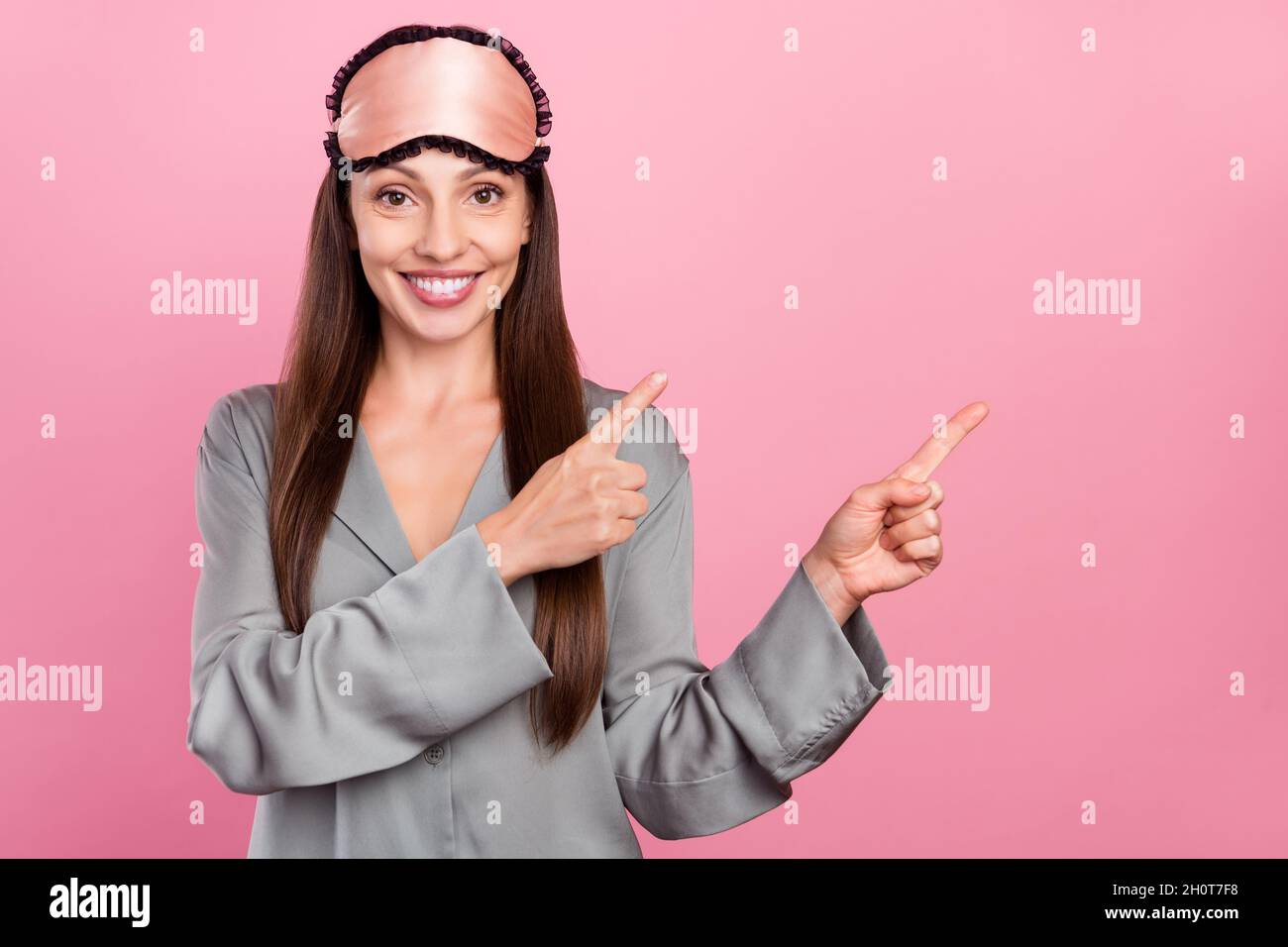 Foto di donna matura felice sorriso positivo indica dita spazio vuoto scegliere diretto annuncio isolato su sfondo rosa colore Foto Stock