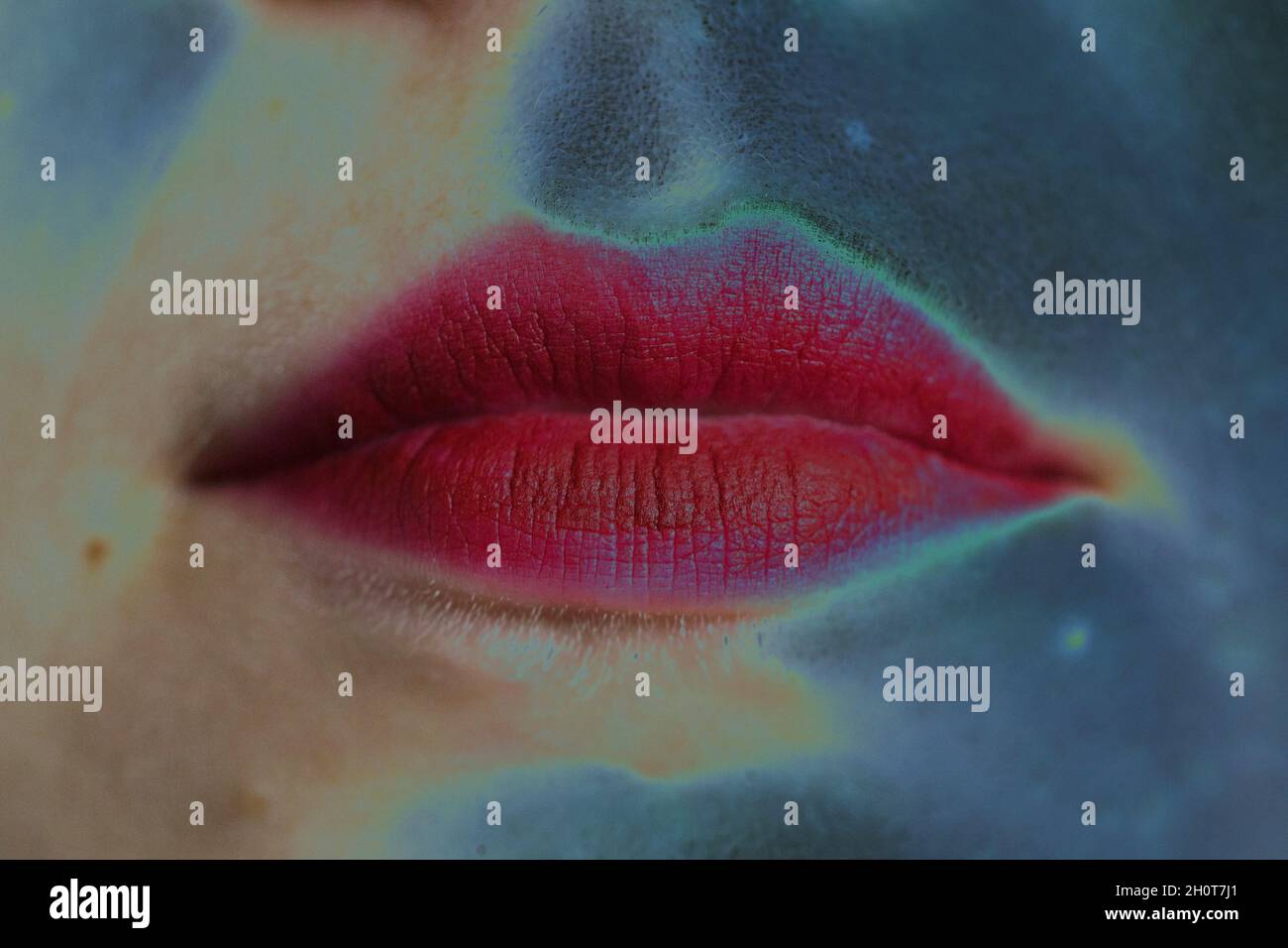 Primo piano delle labbra di una giovane donna con rossetto rosso, solarizzato. Foto Stock