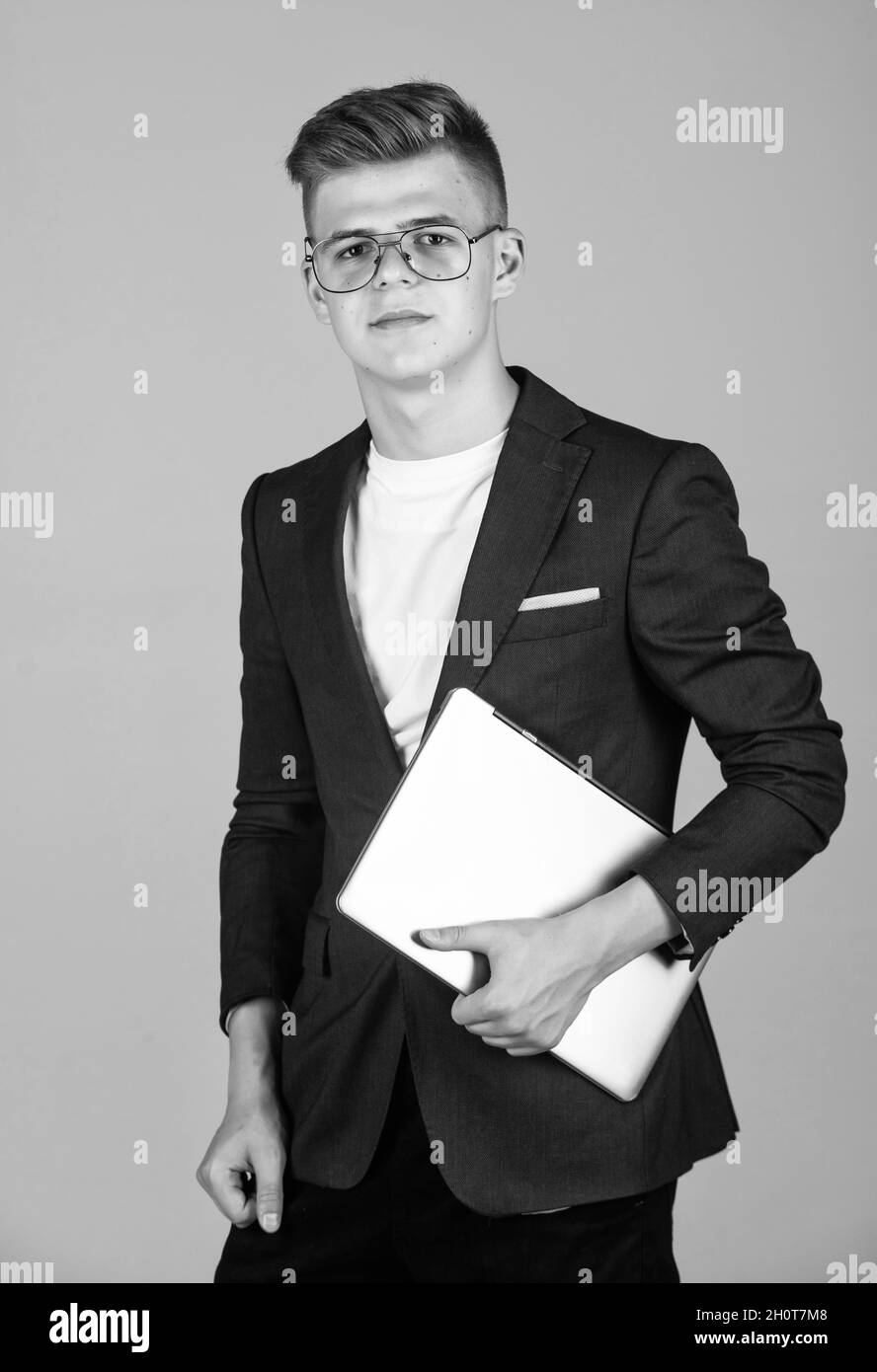 teen boy indossare abiti formali e occhiali utilizzare laptop, business Foto Stock