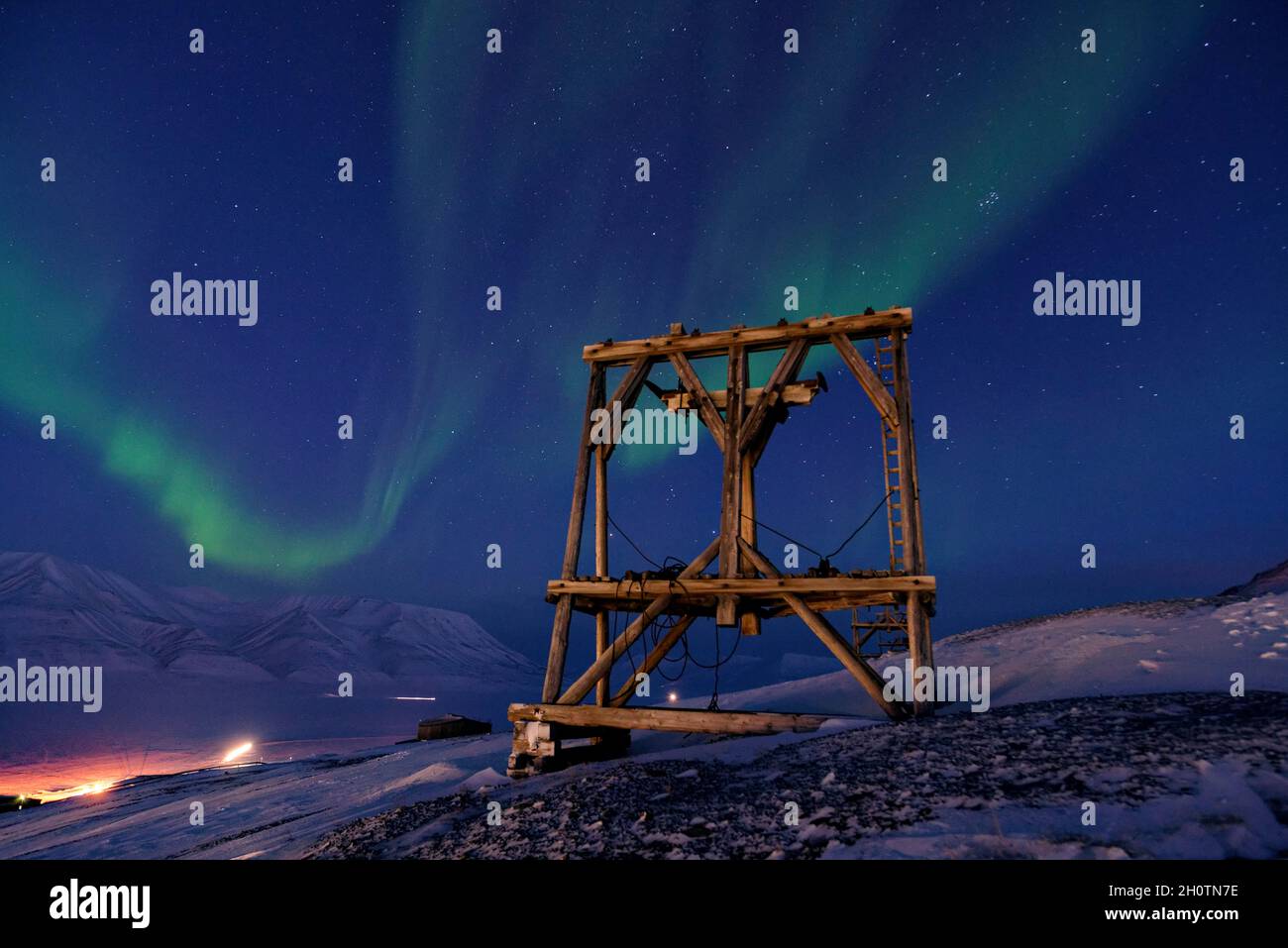 Stagione oscura su Svalbard con notte polare e luci del nord. Traliccio di legno delle antiche tramvie aeree per il trasporto del carbone. Longyearbyen, Spitsbergen Foto Stock