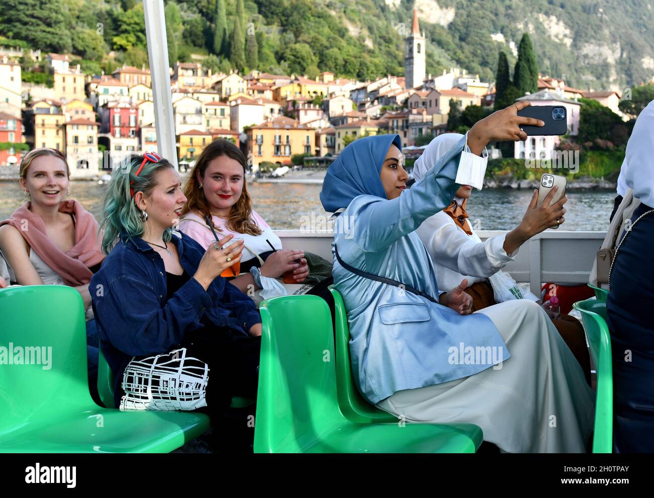 Turisti ragazze donne che scattano una foto selfie in barca Varenna, Lago di Como, Italia Foto Stock