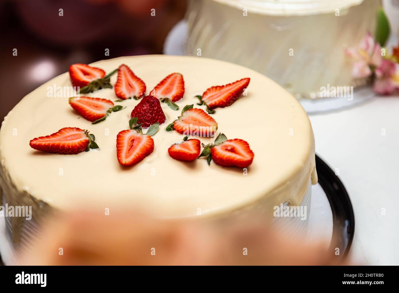 Torta decorata con glassa e fragole su un tavolo decorato per una festa di compleanno. Foto Stock