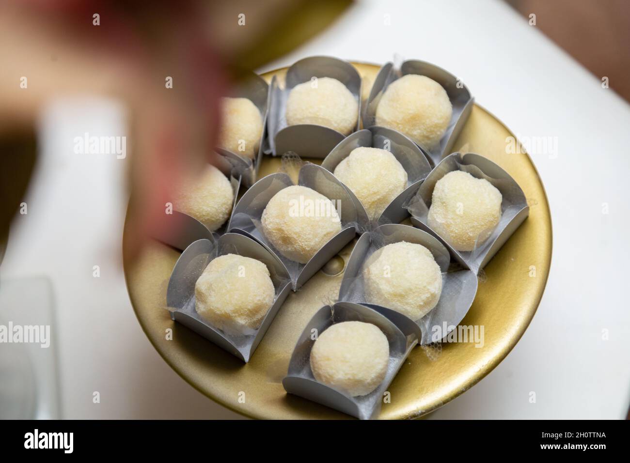 Particolare di dolci a base di latte in polvere e arrotolati, disposti all'interno di un vassoio, sul tavolo da festa. Foto Stock