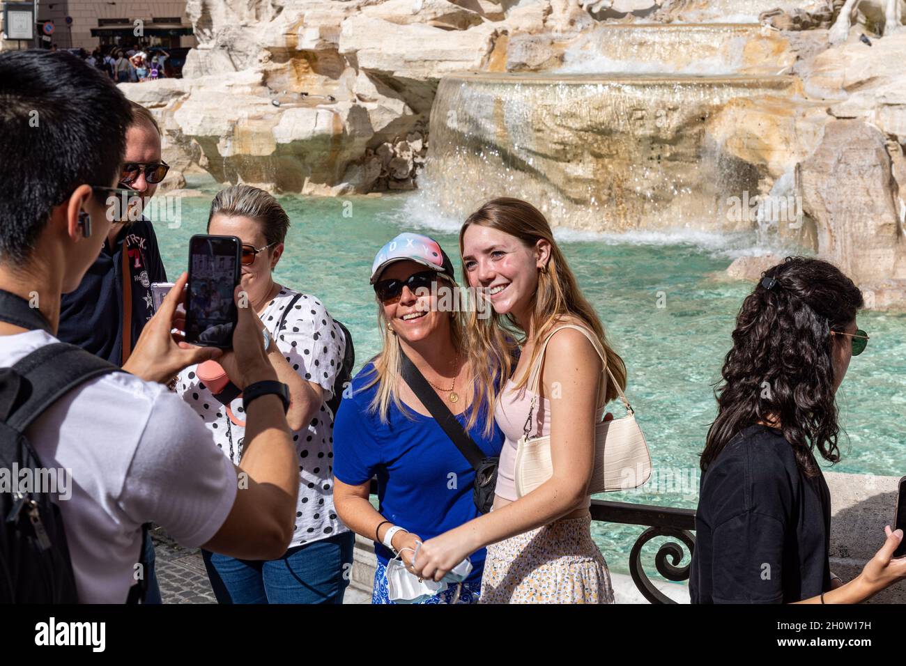 Turisti in posa per foto di viaggio di Fontana di Trevi a Roma, Italia Foto Stock