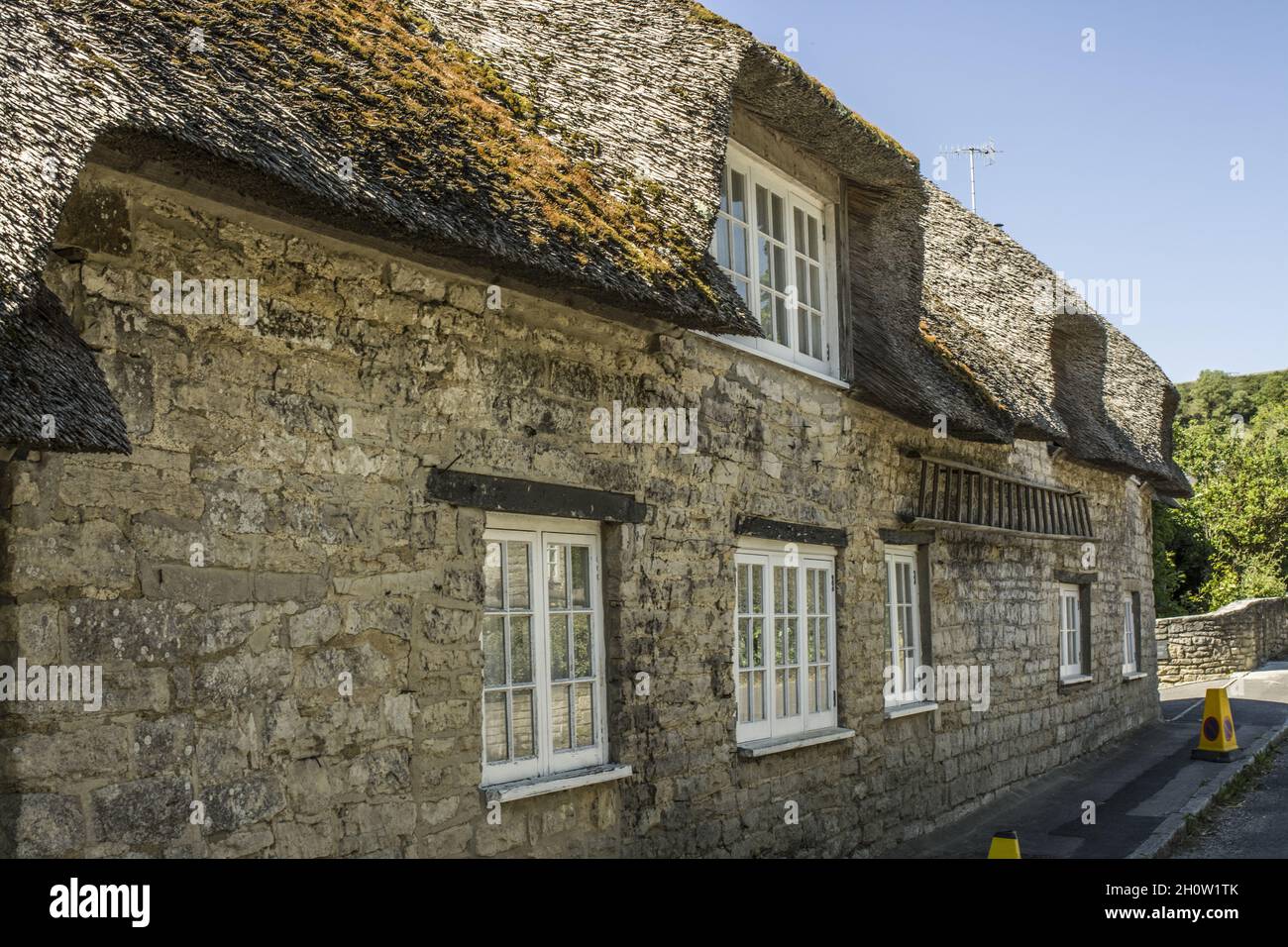 Casa in pietra inglese con tetto di paglia Foto Stock