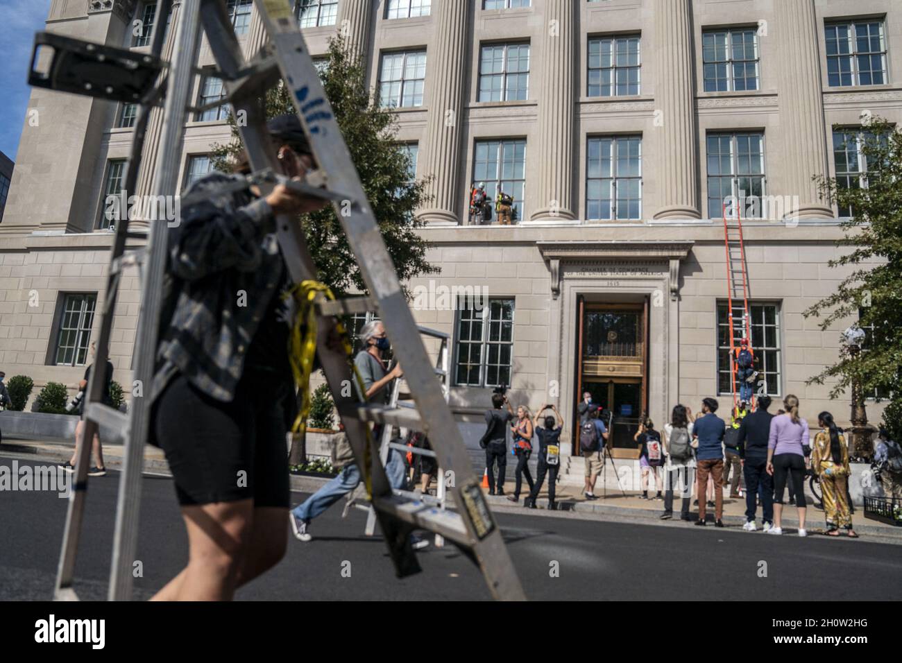 I membri della ribellione di estinzione scalano la Camera di Commercio degli Stati Uniti durante una protesta climatica a Washington, DC, USA, 14 ottobre 2021. Il gruppo d'azione si dimostra contrario all'attuale politica climatica dei governi di tutto il mondo. Foto Stock