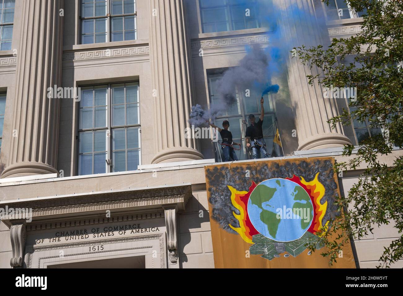 Washington, Stati Uniti. 14 Ott 2021. I manifestanti con il gruppo attivista del cambiamento climatico Extinction Rebellion ridimensionano l'esterno dell'edificio della Camera di Commercio e rilasciano fumo colorato durante una protesta a Washington, DC giovedì 14 ottobre 2021. Foto di Sarah Silbiger/UPI Credit: UPI/Alamy Live News Foto Stock