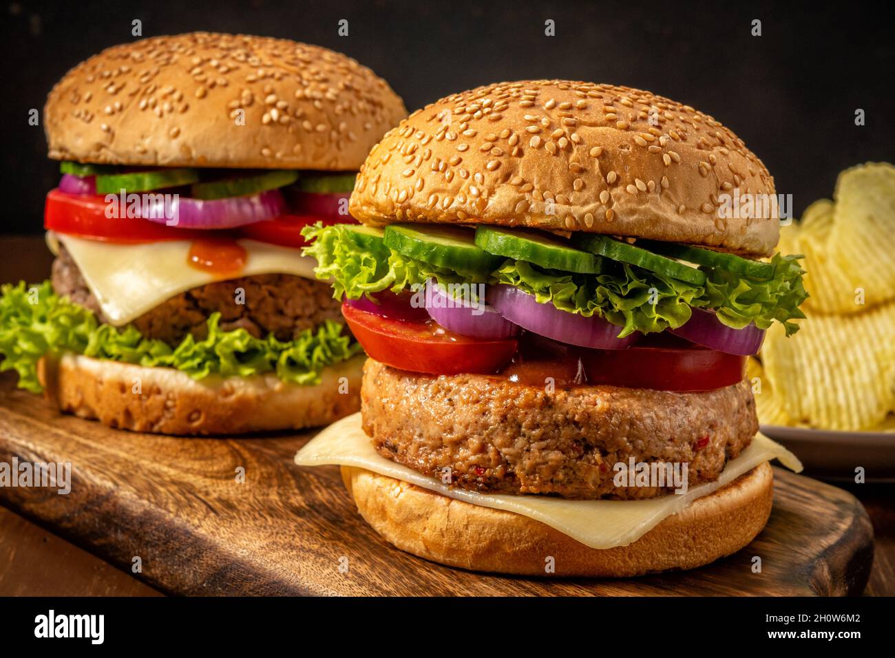 Due gustosi hamburger freschi su un tavolo rustico in legno. Cibo sfondo. Foto Stock