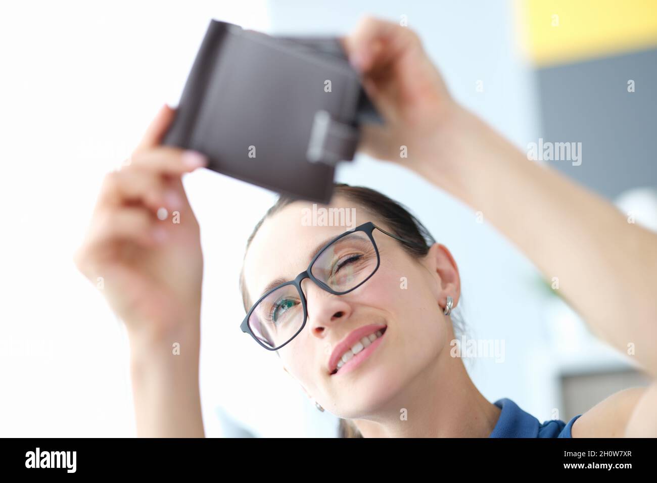 Ritratto di giovane donna con occhiali guarda in borsa vuoto primo piano Foto Stock