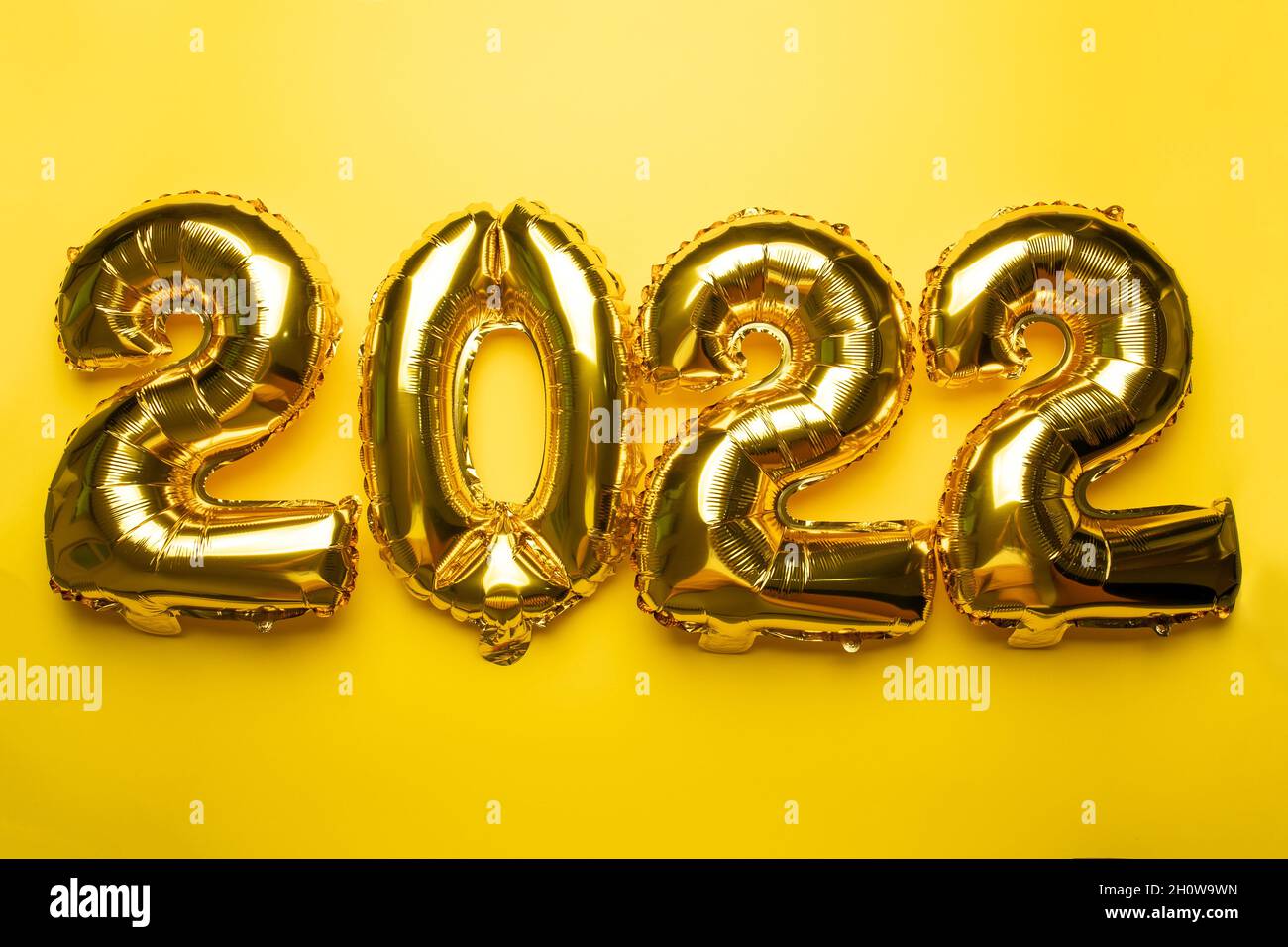 2022 Concept Capodanno da palloncino in lamina d'oro su sfondo giallo foto stock Foto Stock