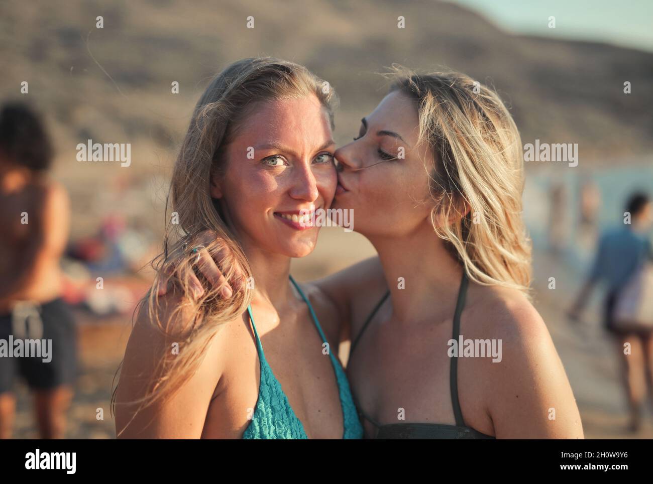 la giovane donna bacia la sua amica in spiaggia Foto Stock