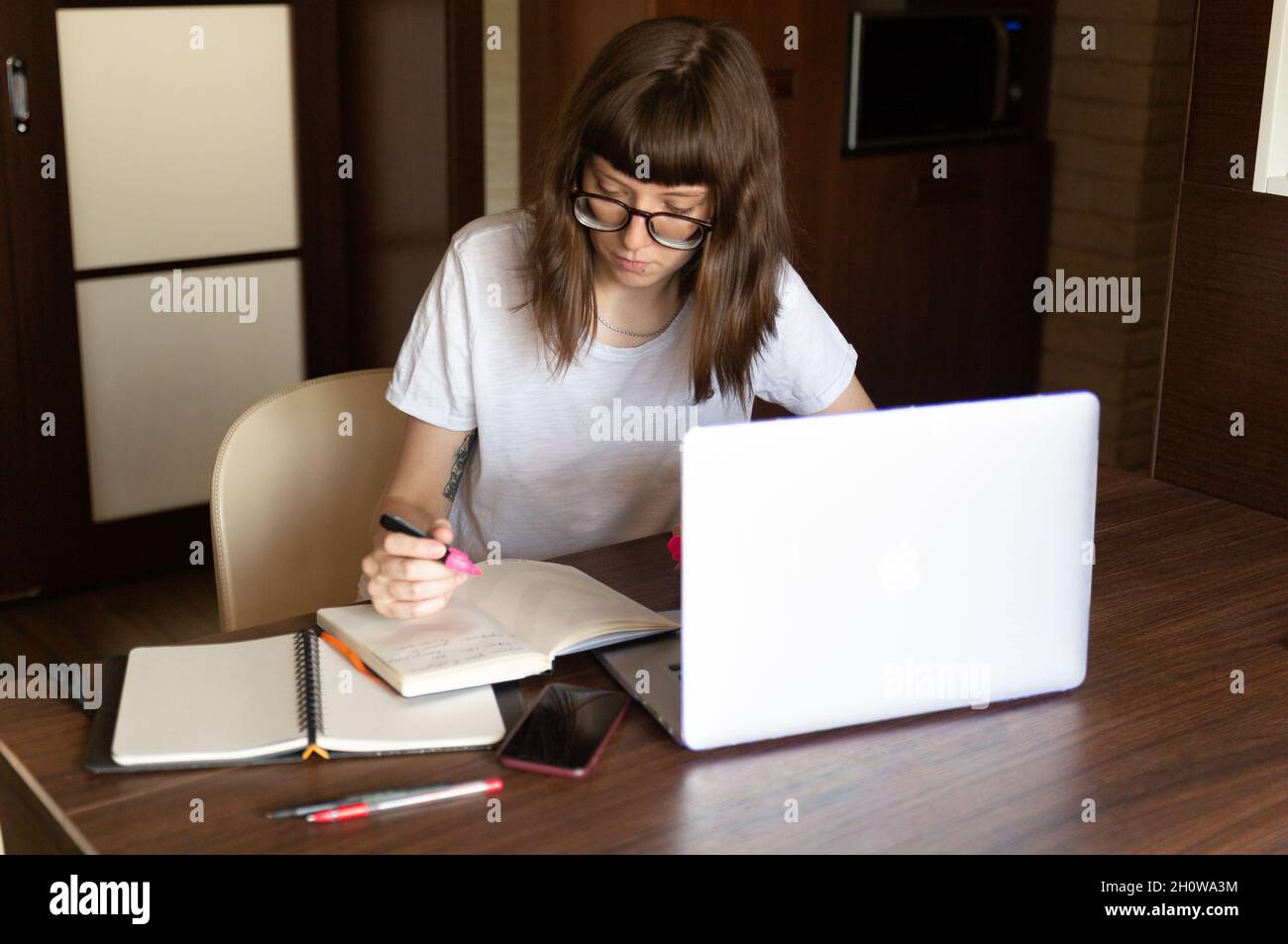 Donna al lavoro su laptop a tavola Foto Stock