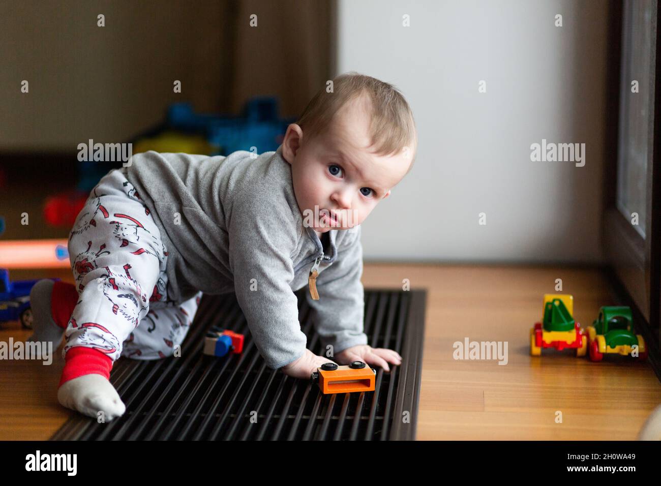 Bambino ragazzo carino che gioca i giocattoli sul pavimento Foto Stock