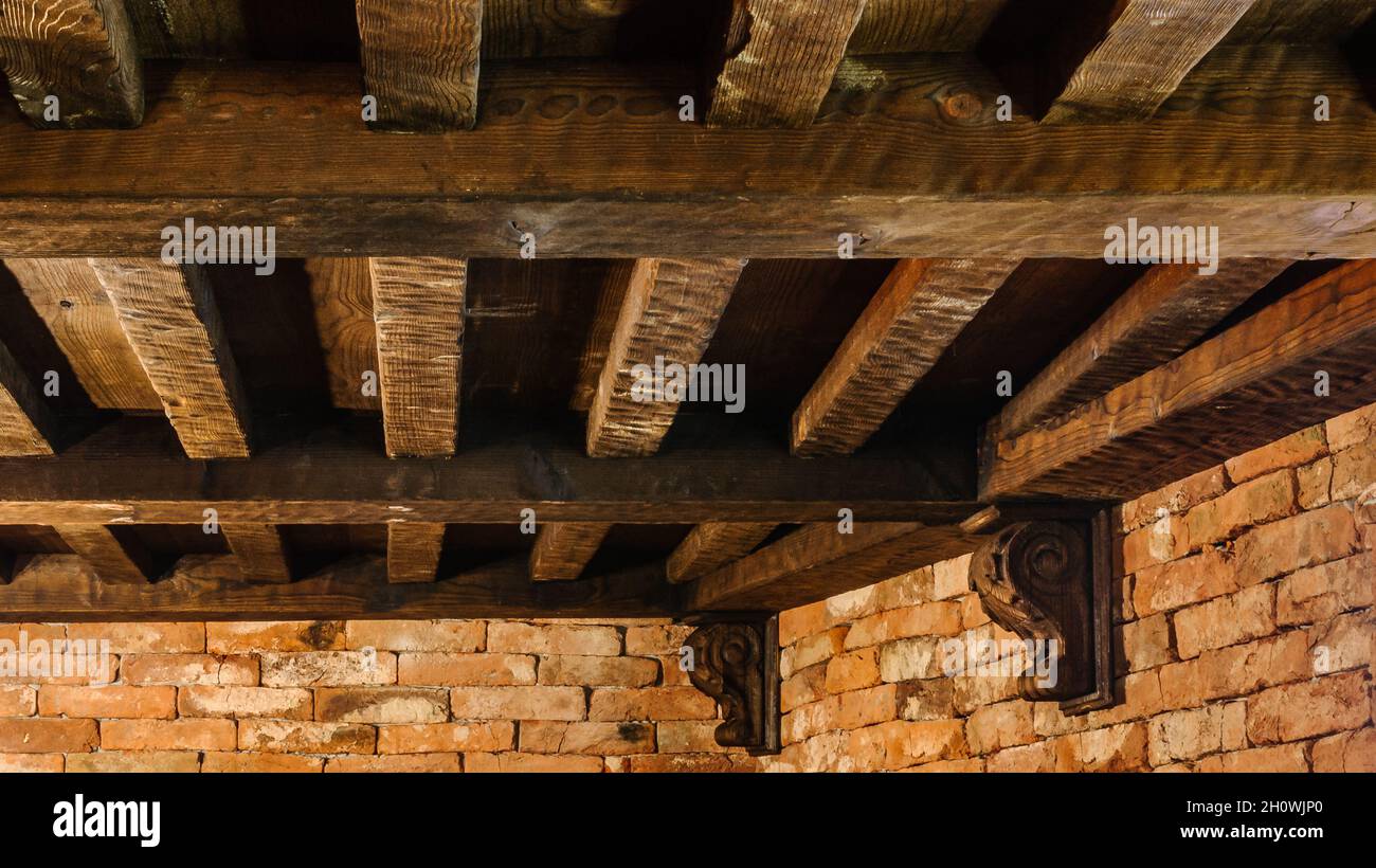 travetti in legno a soffitto con travi massicce in una casa in un vecchio stile tradizionale Foto Stock